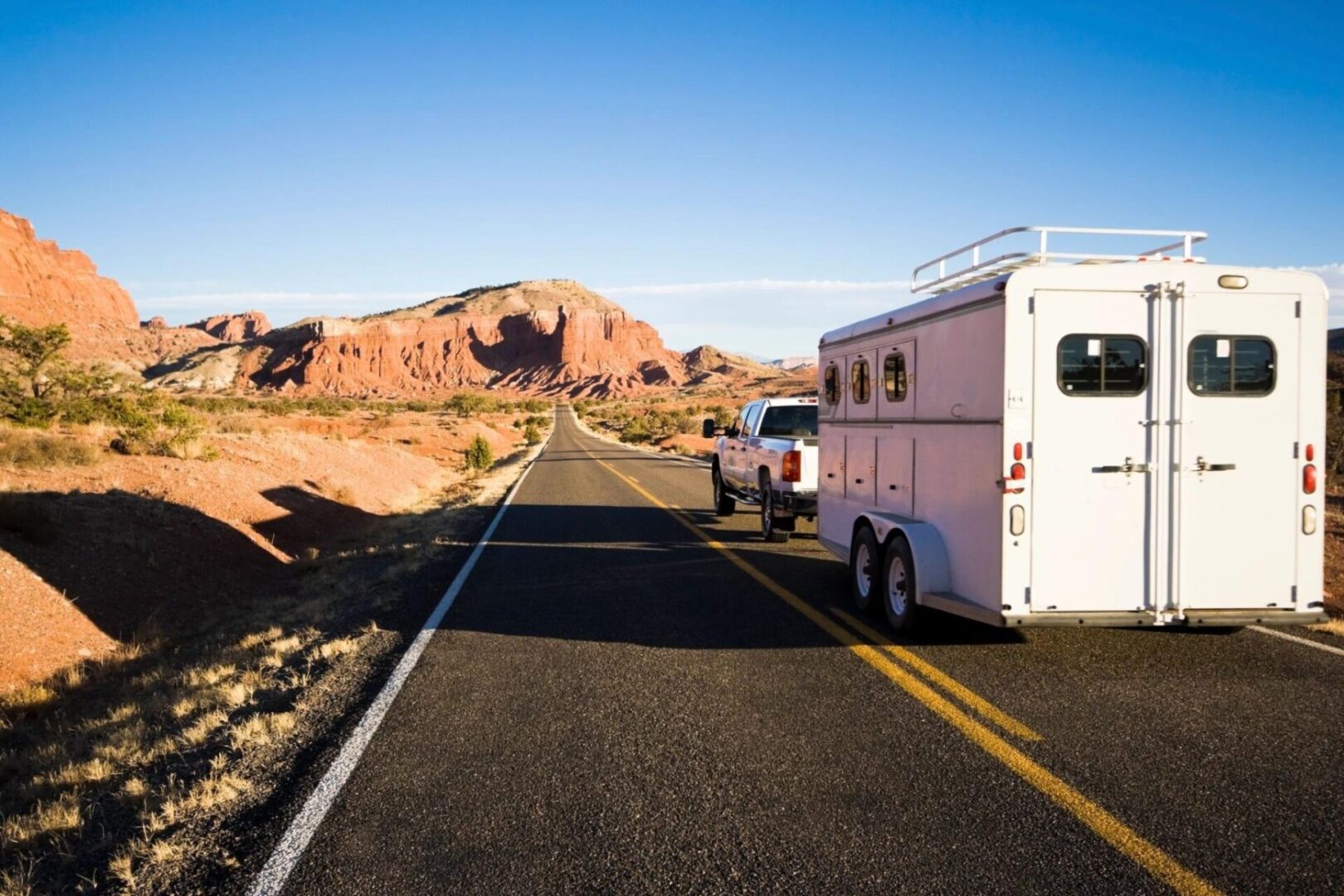 A horse trailer is parked on the side of a road.